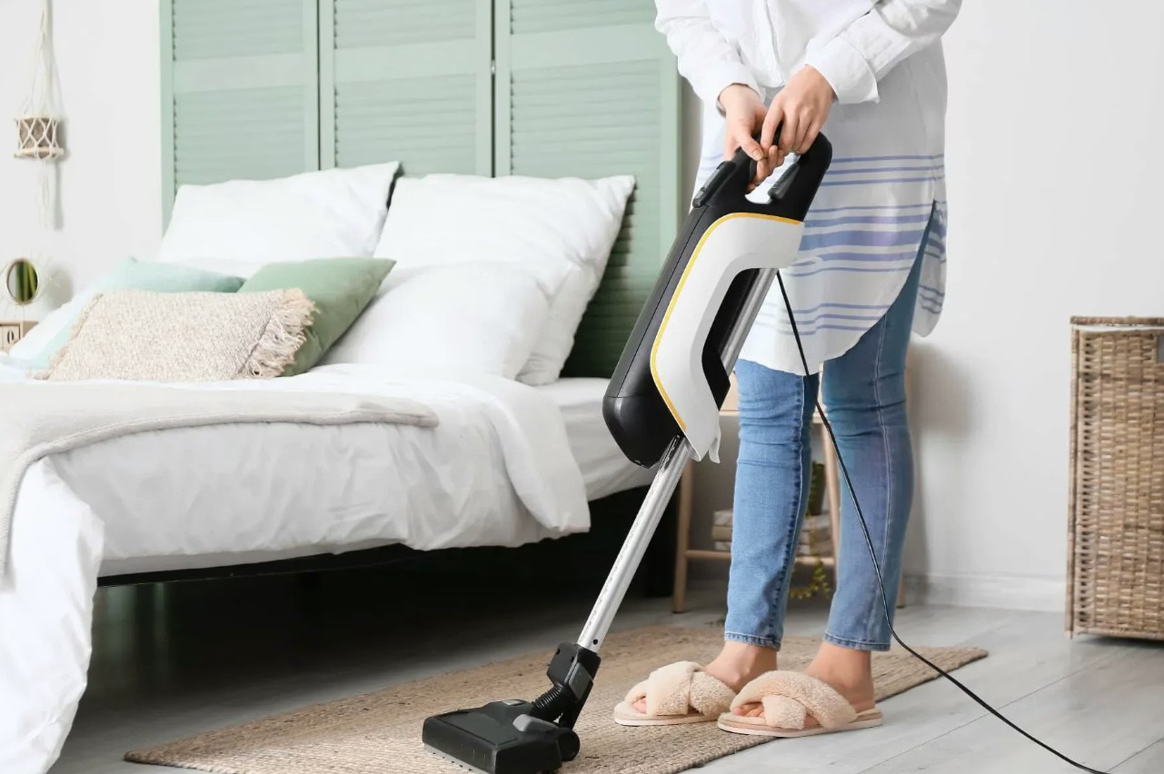 Vacuuming a bright bedroom
